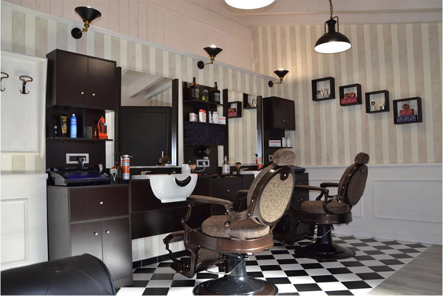 Un barbiere in stile vintage con la "Postazione di lavoro Combo", su un classico pavimento a scacchi bianco e nero.