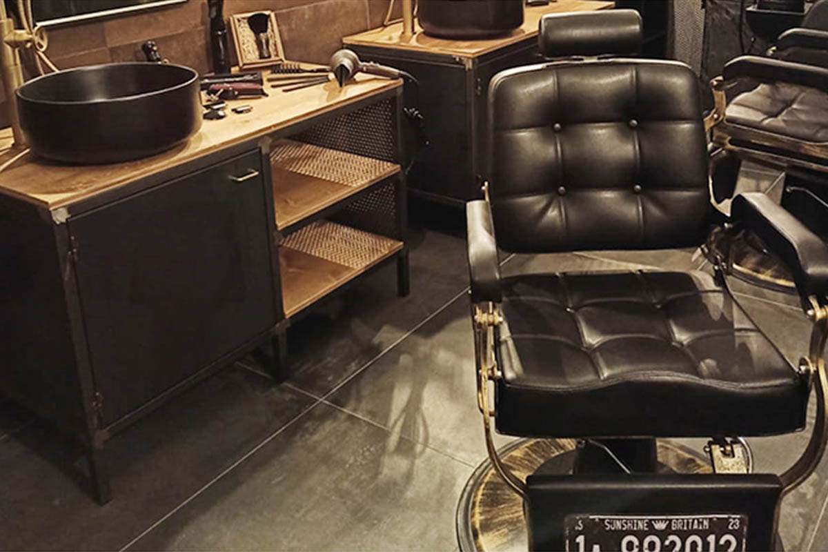 Un barbiere in stile vintage con un'elegante barbiere Poltrona Targa e mobili in legno